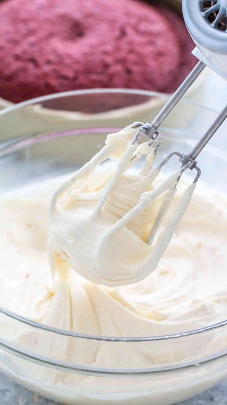 a mixer mixing cream in a glass bowl