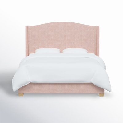 a bed with a pink headboard and white linens on the bottom, in front of a light colored wall