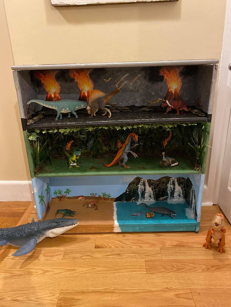 a toy dinosaur is standing in front of a bookcase with fake dinosaurs on it