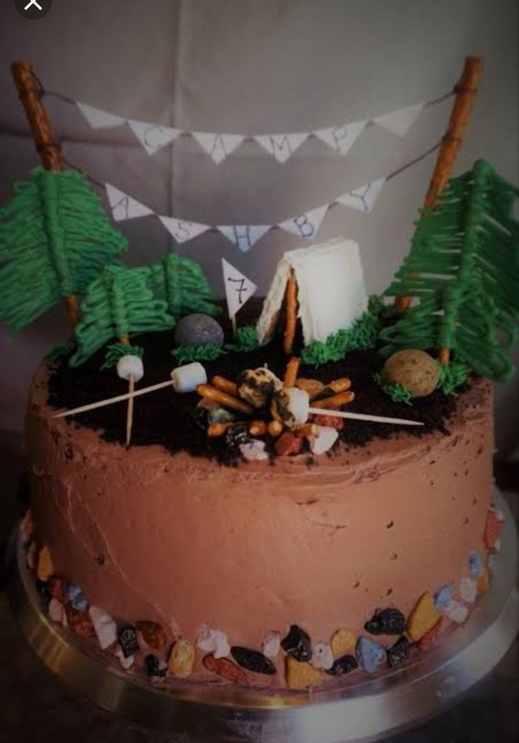 a chocolate cake decorated with trees and rocks