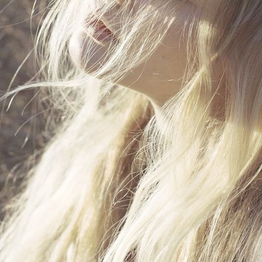 a woman with long blonde hair standing in the sun