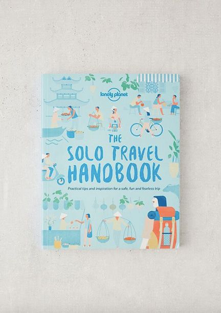 the solo travel handbook book on a white surface with an illustration of people and boats