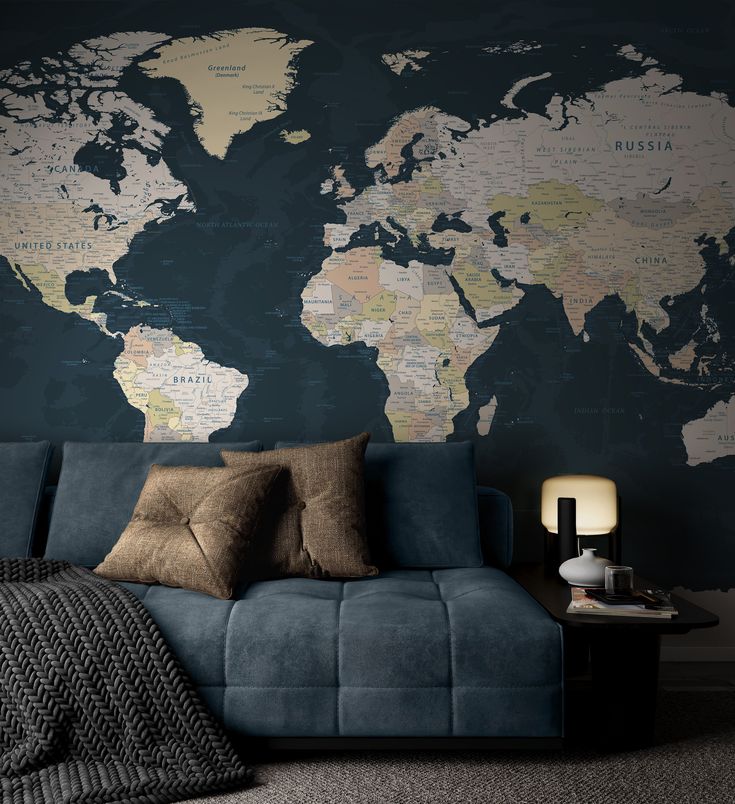 a blue couch sitting in front of a wall with a world map on the wall