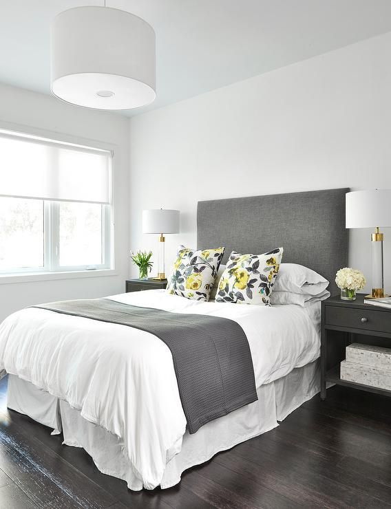 a bedroom with white walls and wood floors