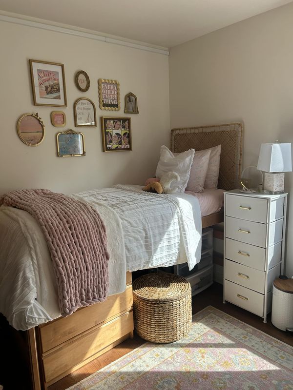 a bedroom with a bed, dresser and pictures on the wall