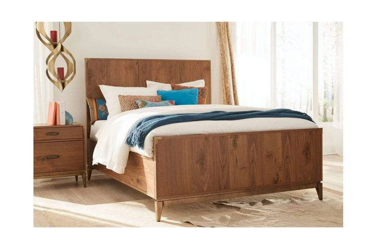 a bed with wooden headboard and foot board on top of carpeted flooring