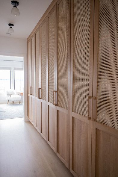 a hallway with wooden cabinets and white walls