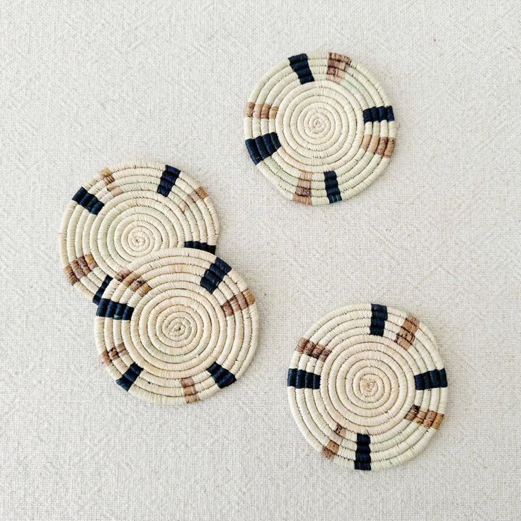 three woven coasters sitting on top of a white table next to eachother