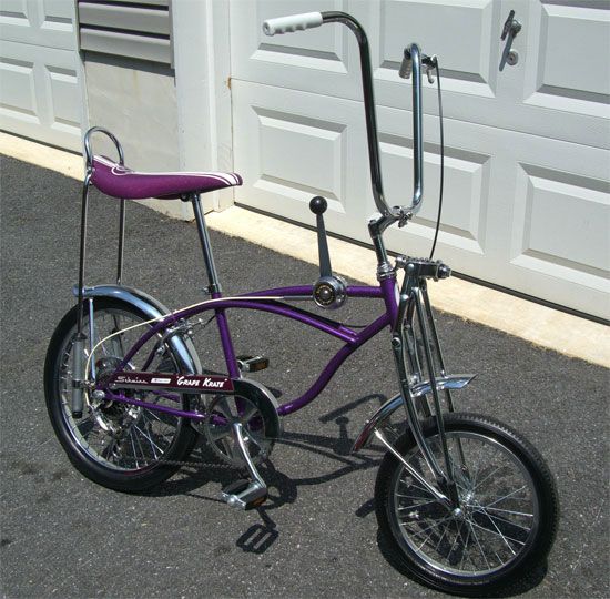 a purple bicycle parked in front of a garage door