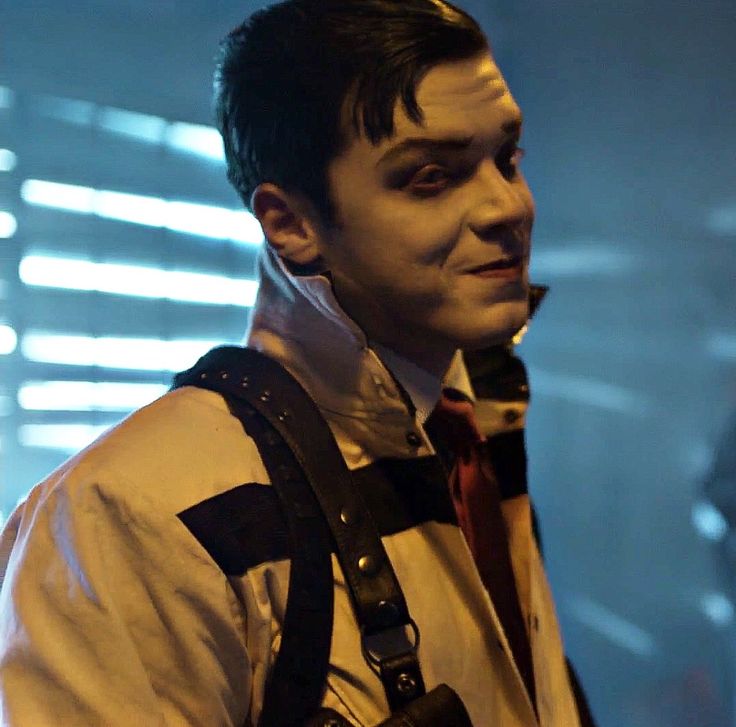 a man dressed in costume with suspenders and a creepy look on his face while holding a camera