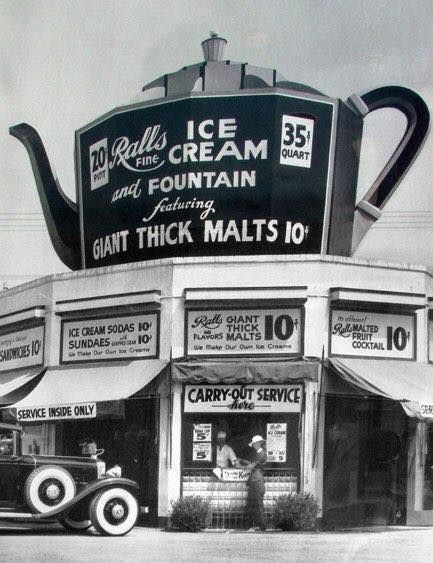 an old black and white photo shows the front of a ice cream shop with cars parked outside