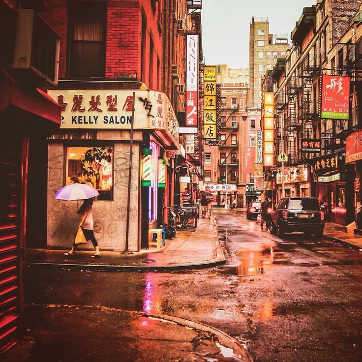 a wet city street with people walking on it