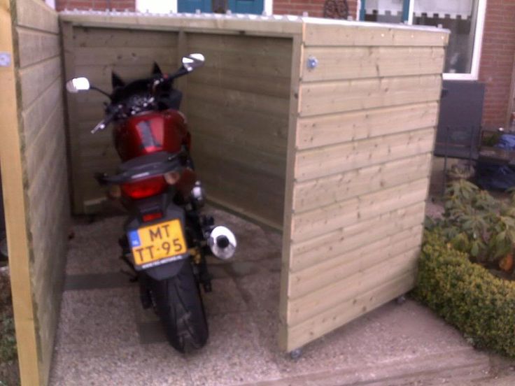 a motorcycle parked in front of a wooden shed