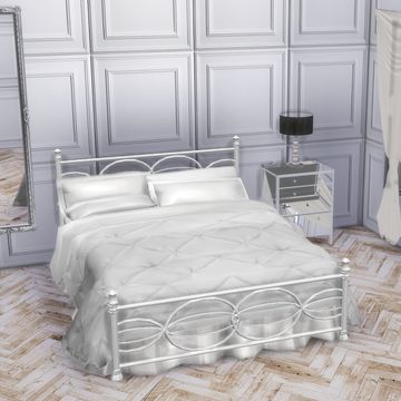 a white bed sitting in a bedroom next to a dresser and mirror on top of a hard wood floor