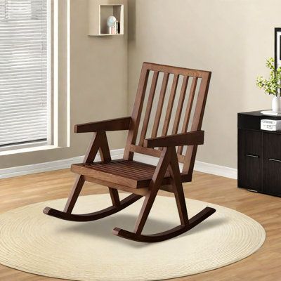 a wooden rocking chair sitting on top of a white rug