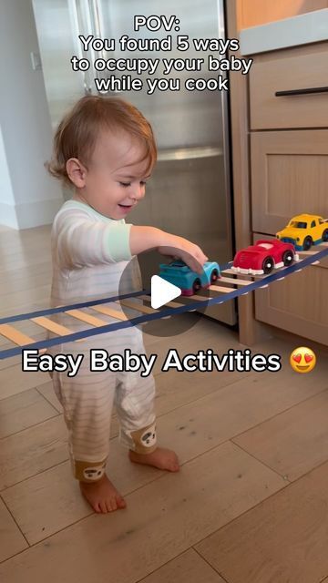 a toddler playing with toy cars on a rail in the kitchen while text reads, you found 5 ways to occupy your baby while you cook