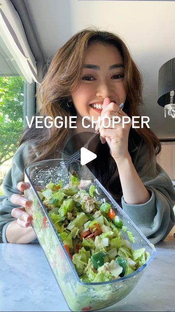 a woman sitting at a table with a bowl of salad in front of her and the words veggie chopper on it