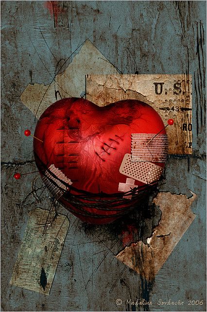 a red heart sitting on top of a piece of paper next to a torn up sign