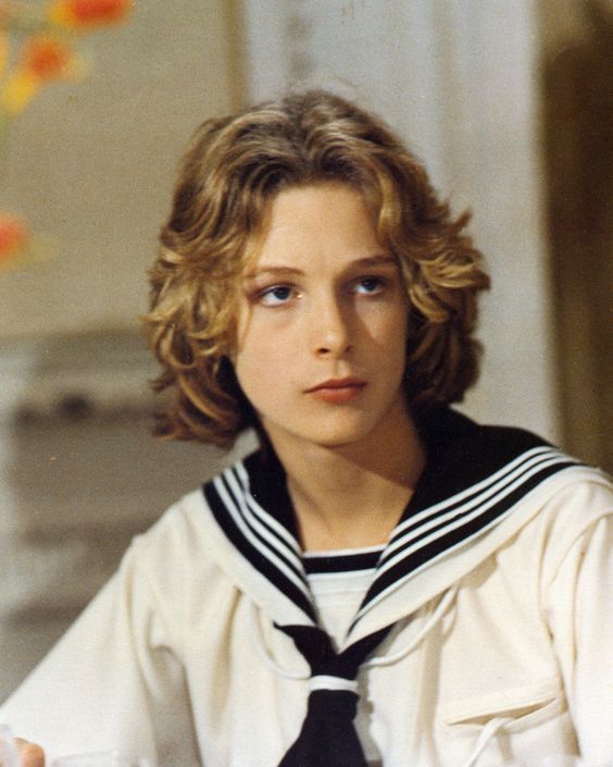 a young woman wearing a sailor's outfit sitting at a table