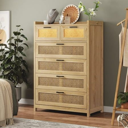 a wooden cabinet with wicker doors in a room next to a rug and potted plant