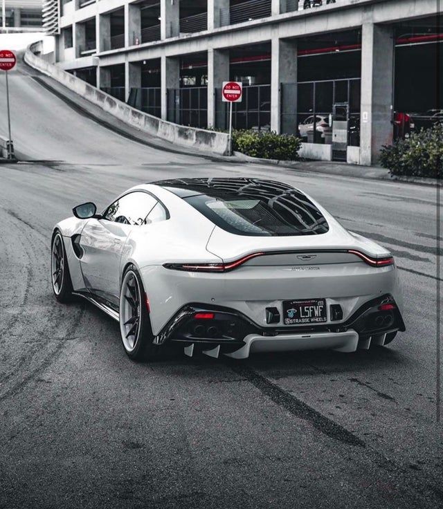 a white sports car parked in front of a building