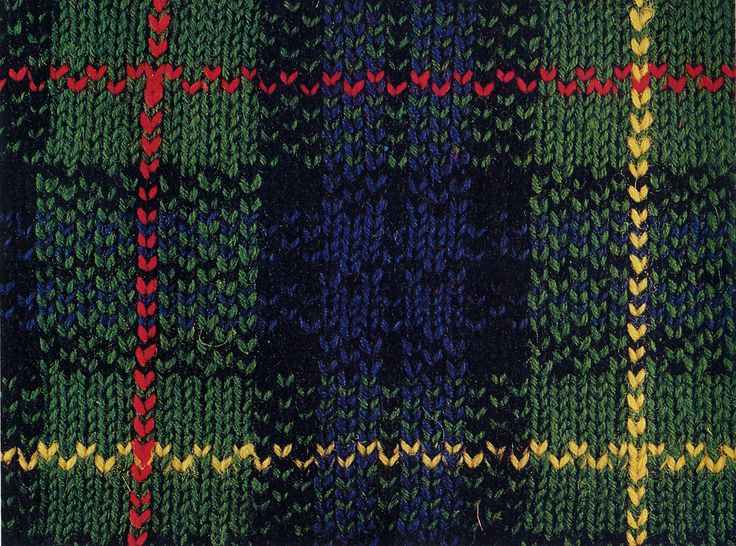 a close up of a knitted cloth with different colors and designs on it,