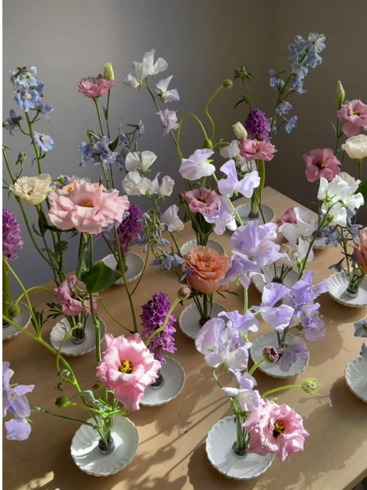 a table topped with lots of vases filled with different types of flowers on top of it