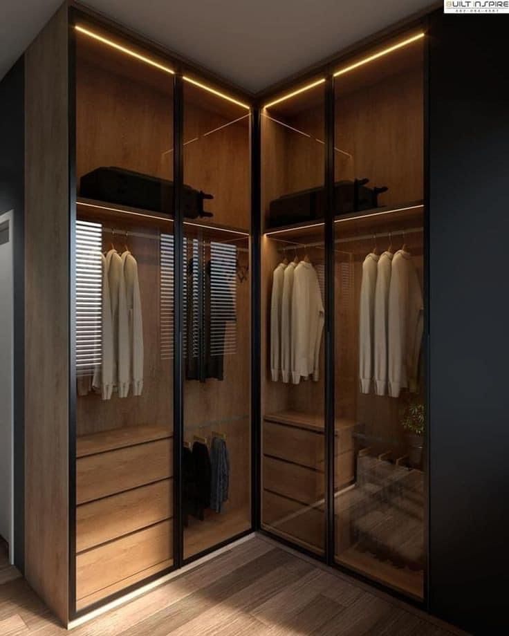 an empty walk in closet with clothes on hangers and shirts hanging from the doors