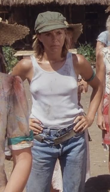 a woman in white shirt and jeans standing next to other women