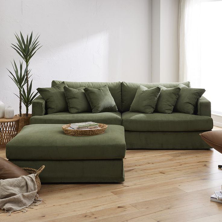 a living room with a green couch and ottoman