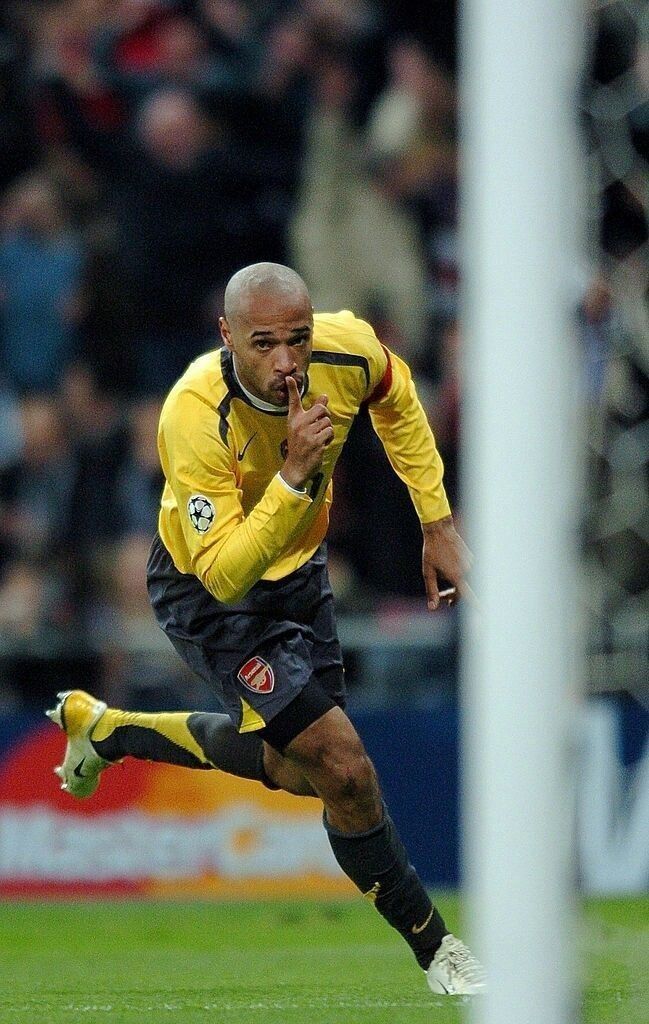 a soccer player is running with the ball in front of him and people watching from the stands