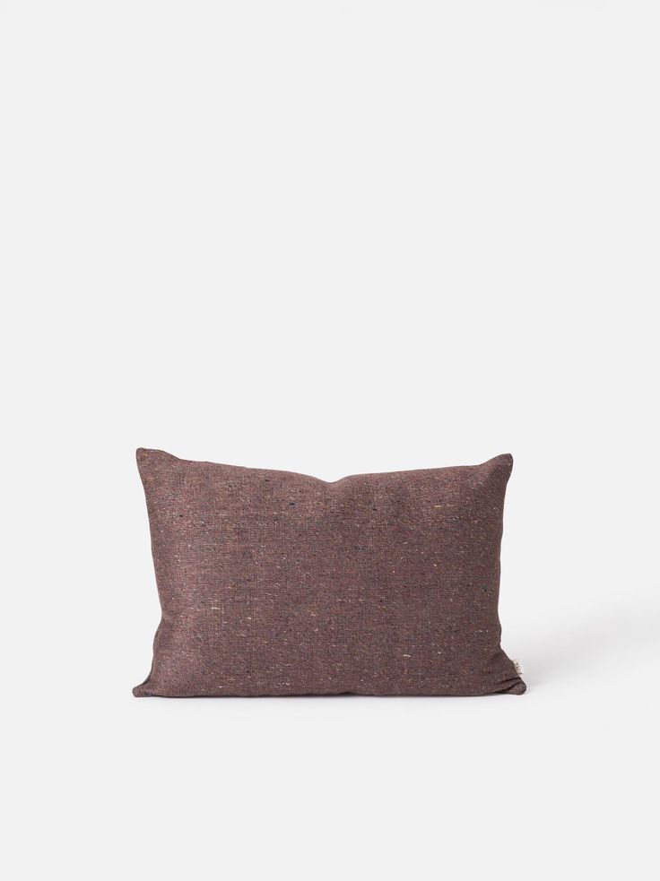 a brown pillow sitting on top of a white wall