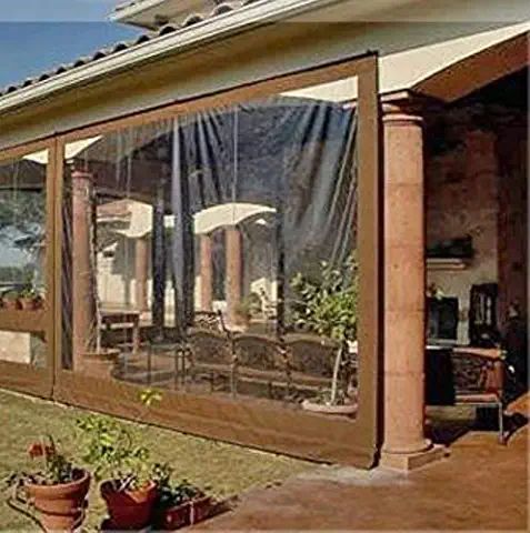 a patio covered in curtains with potted plants on the side of it and an outside dining area