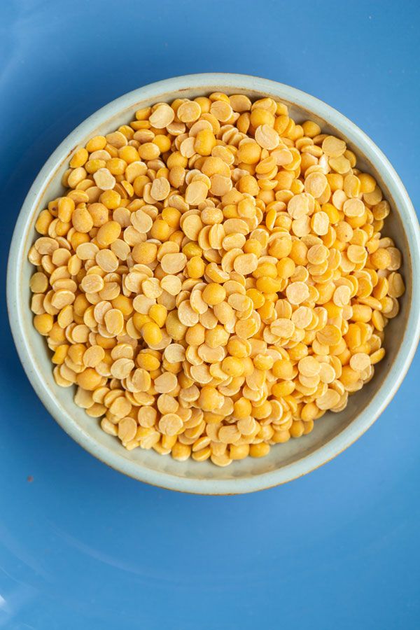 a white bowl filled with corn on top of a blue table