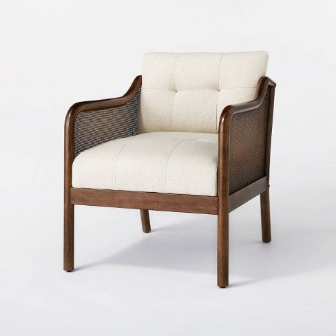 the chair is made from wood and has a white upholstered fabric on it