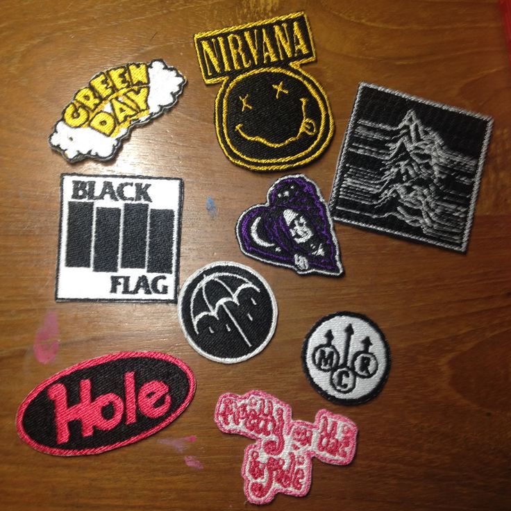 various patches and stickers on a wooden table with the words black flag written in them