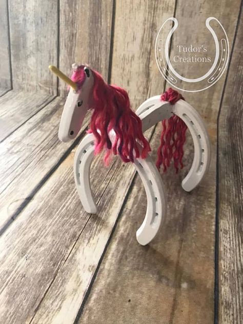 a pink and white toy horse sitting on top of a wooden floor next to a wall