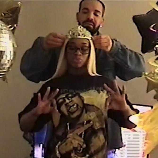 a man and woman standing next to each other in front of a mirror wearing crowns