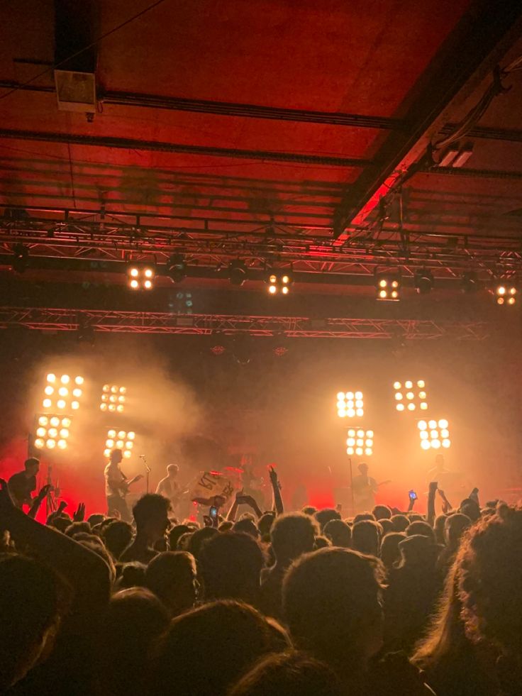 a group of people standing on top of a stage with lights in the air above them