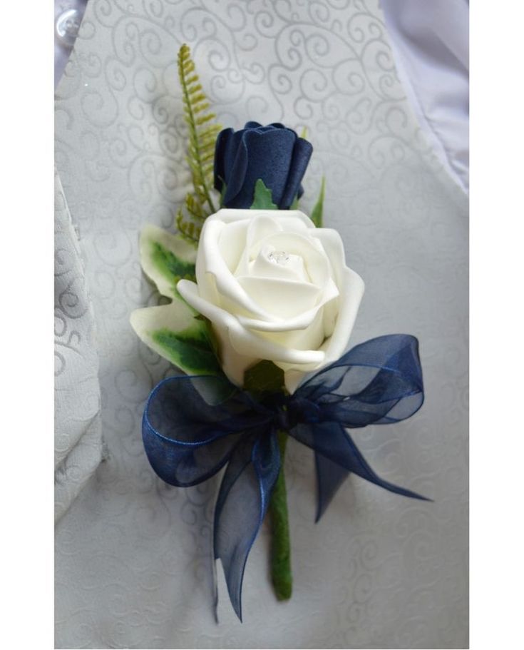 two different pictures one with a white rose and the other has blue ribbon on it