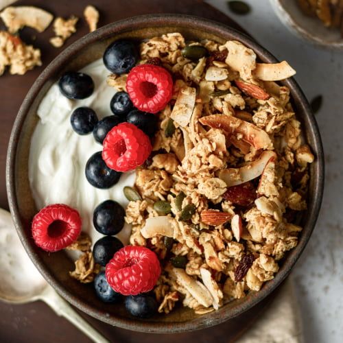 a bowl filled with granola, berries and yogurt