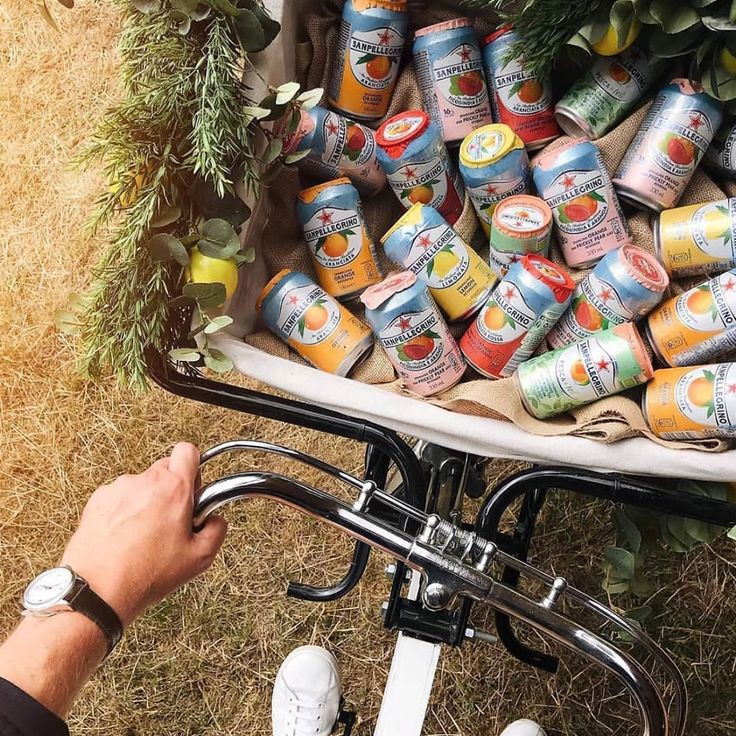 a man is riding his bike with many cans on it