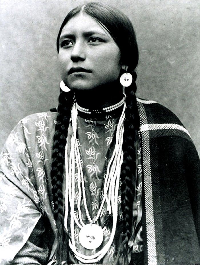 an old black and white photo of a woman with long braids