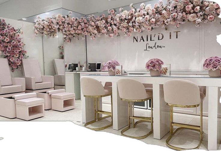 the interior of a nail salon decorated with pink flowers