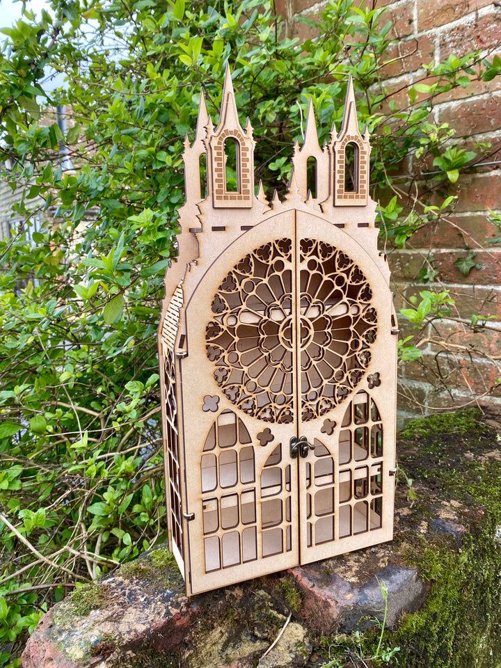 an intricately carved wooden door sits on a rock in front of a brick wall