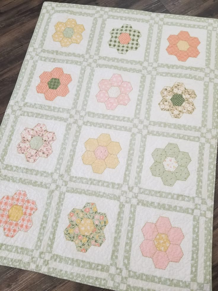 a quilted table topper with many different designs on it, including flowers and circles