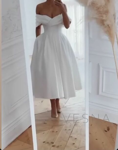 a woman in a white dress is taking a selfie