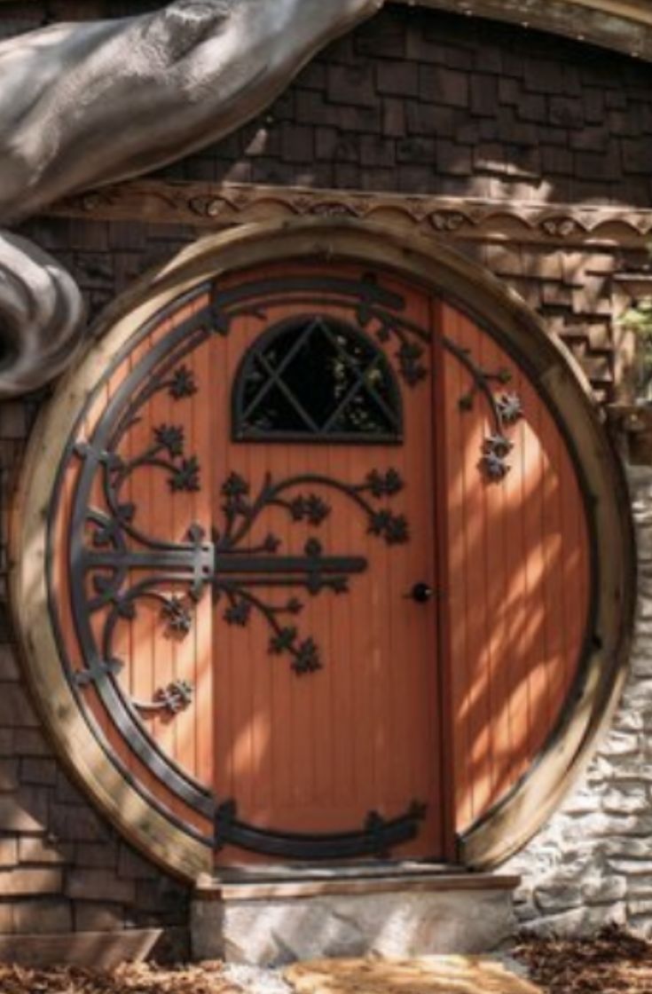 a large wooden door in the side of a brick building with a horse statue next to it