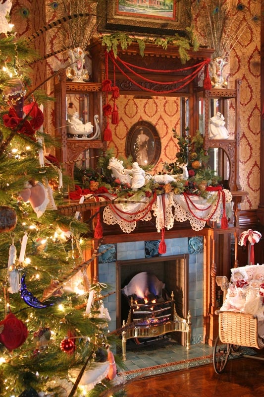 a decorated christmas tree sitting in front of a fire place with presents on the mantle