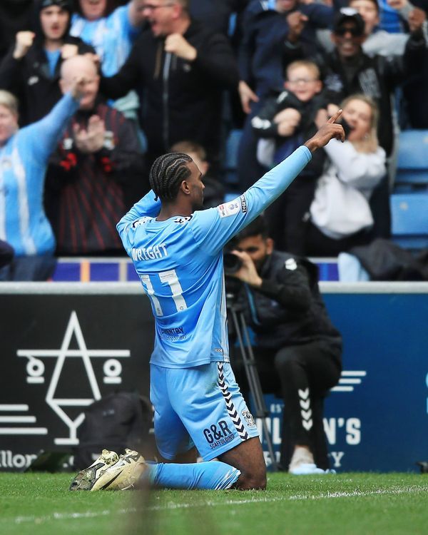 a soccer player sitting on the ground with his arms in the air as he celebrates